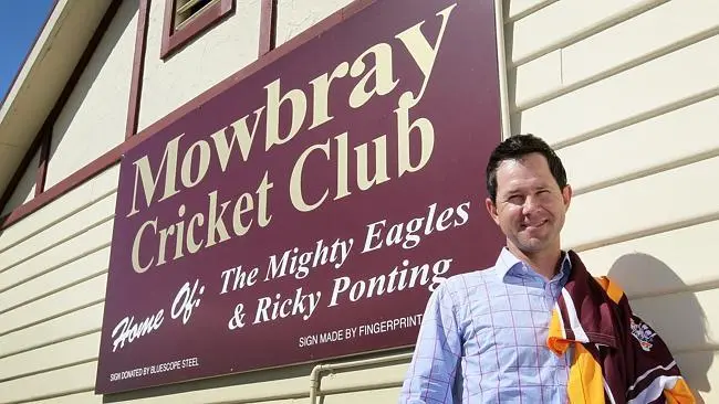 Mowbray Cricket Club sign with a smiling man.