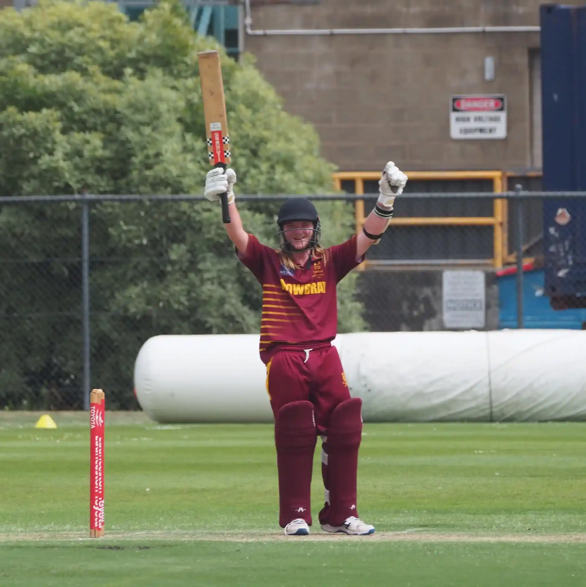 Cricketer celebrating in maroon uniform